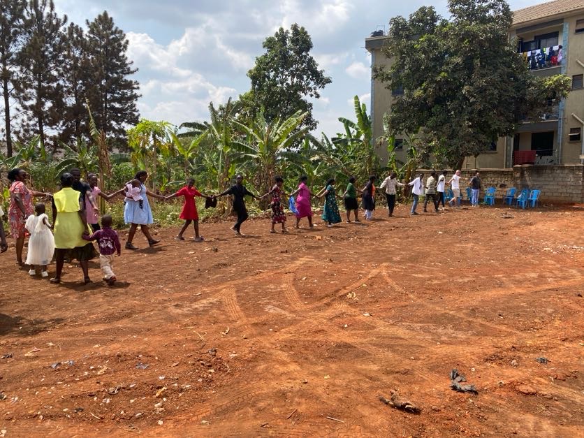 Community members holding hands in a circle on the purchased land.