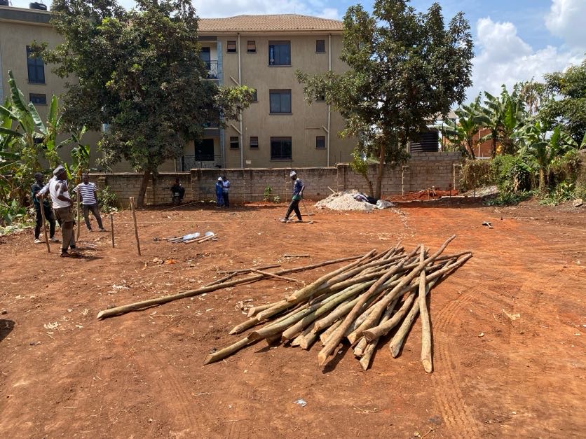 The purchased land with people on site and timber gathered in the foreground.
